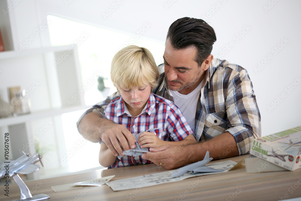 Father and kid making a plane model Father and kid making a plane model