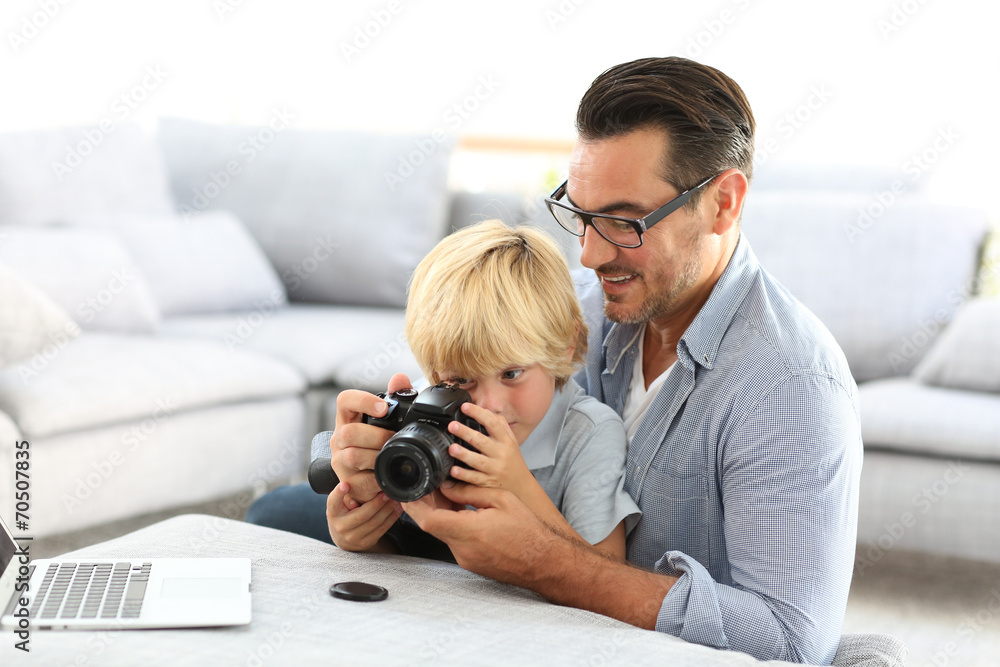 Man with little boy playing with reflex camera Man with little boy playing with reflex camera