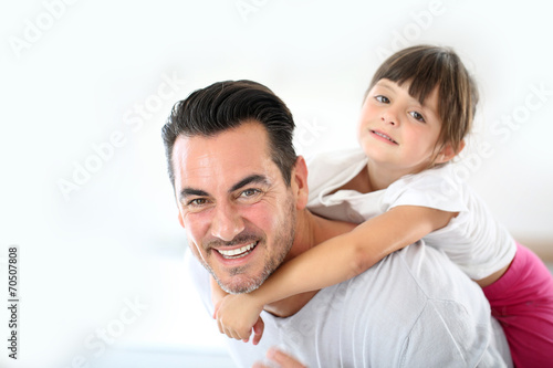 Daddy carrying little girl on his back