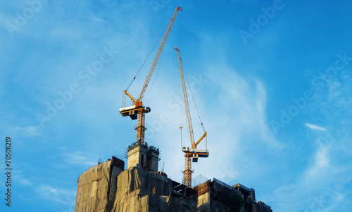 Construction site with cranes with blue sky background