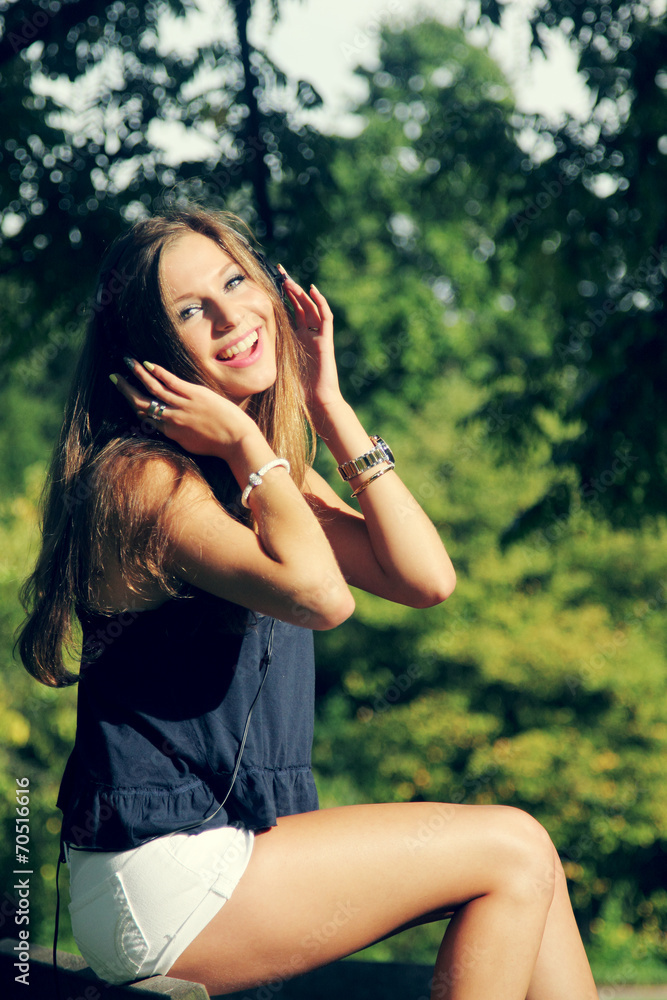 Beautiful Young Woman with Headphones Outdoors Beautiful Young Woman with Headphones Outdoors