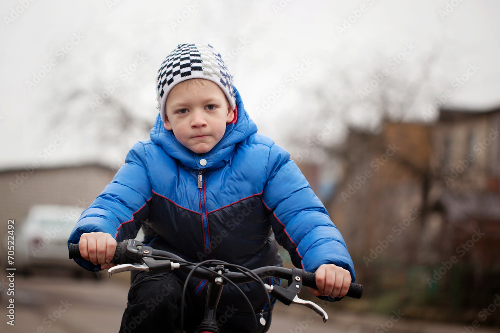 Portrait of a little girl on a bicycle in the cold autumn Portrait of a little girl on a bicycle in the cold autumn
