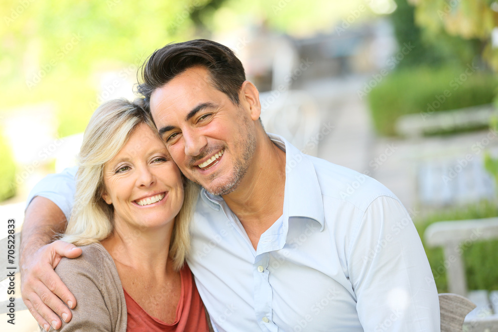 Portrait of loving mature couple relaxing on bench