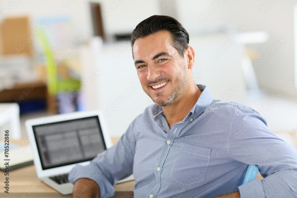 Businessman sitting in office and working on laptop Businessman sitting in office and working on laptop