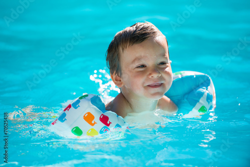 enfant avec des brassards- à la piscine photo