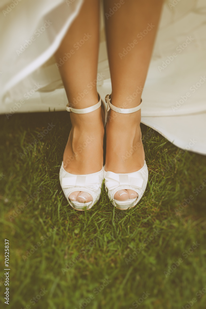 Bride's White Shoes on a Grass Field