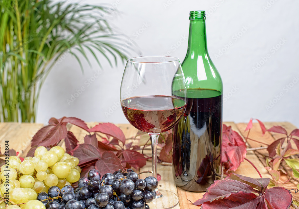 glass of red wine with many bunches of grapes