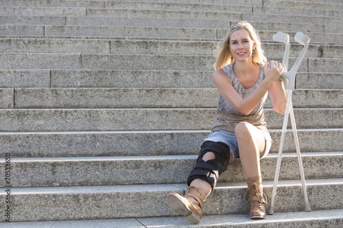 Fotobehang blonde woman with crutches