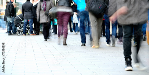 Motion blurred pedestrians on sidewalk