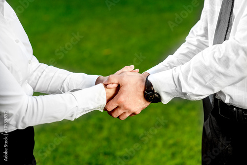 Business couple shaking hands outdoors
