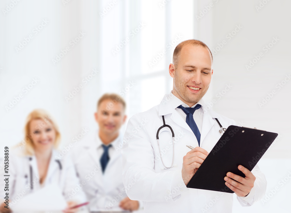 smiling male doctor with clipboard and stethoscope smiling male doctor with clipboard and stethoscope
