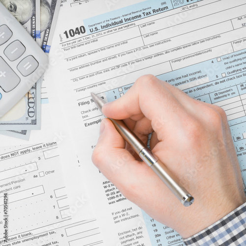 Male filling out 1040 US Tax Form - 1 to 1 ratio © niyazz