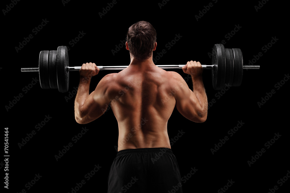 Studio shot of a bodybuilder lifting a barbell Studio shot of a bodybuilder lifting a barbell