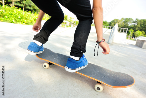 skateboarding woman legs jump at skatepark 