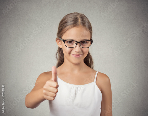 Happy teenager girl with glasses showing thumbs up