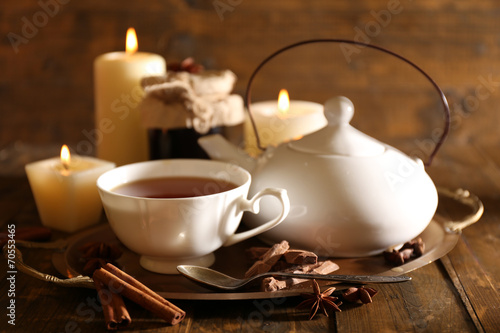 Composition with tea in cup and teapot and candles