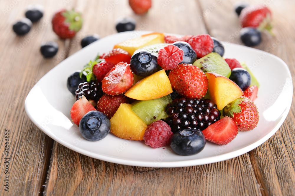 Delicious fruits salad in plate on table close-up Delicious fruits salad in plate on table close-up