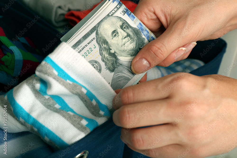 Fotografie Woman hiding money in sock close up