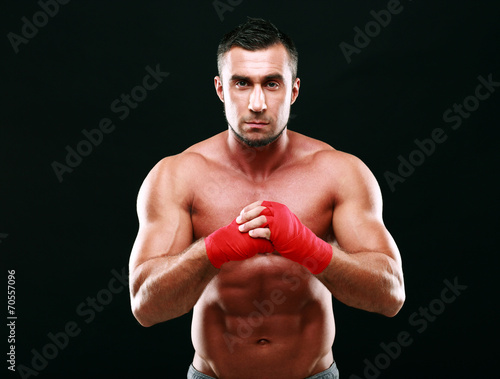 Portrait of serious muscular man on a black background © Drobot Dean