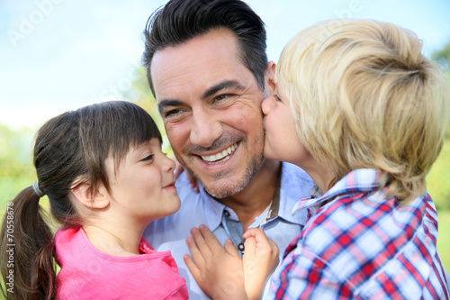 Portrait of kids giving a kiss to their daddy