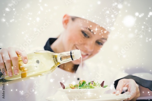 Smiling woman chef dressing a salad