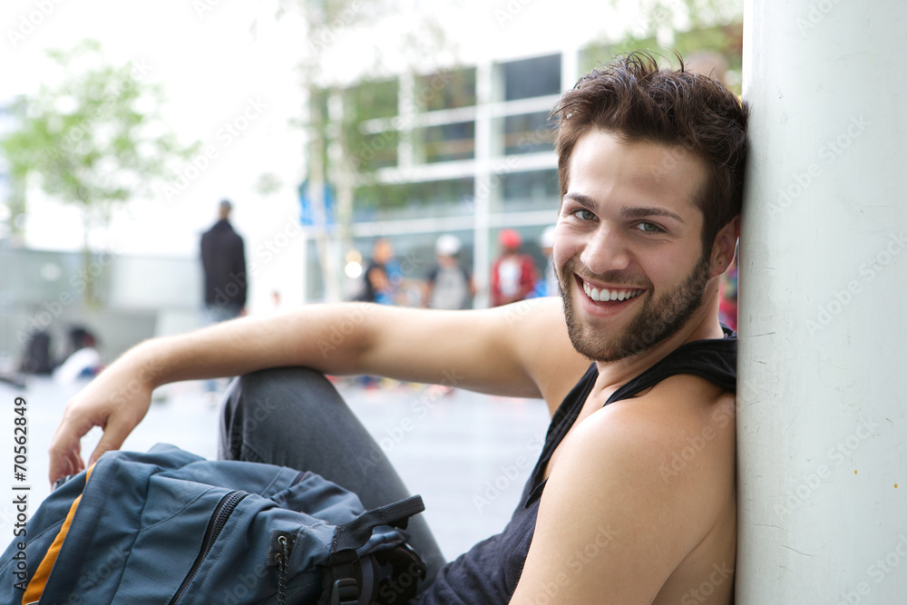 Cool guy sitting outdoors with bag Cool guy sitting outdoors with bag