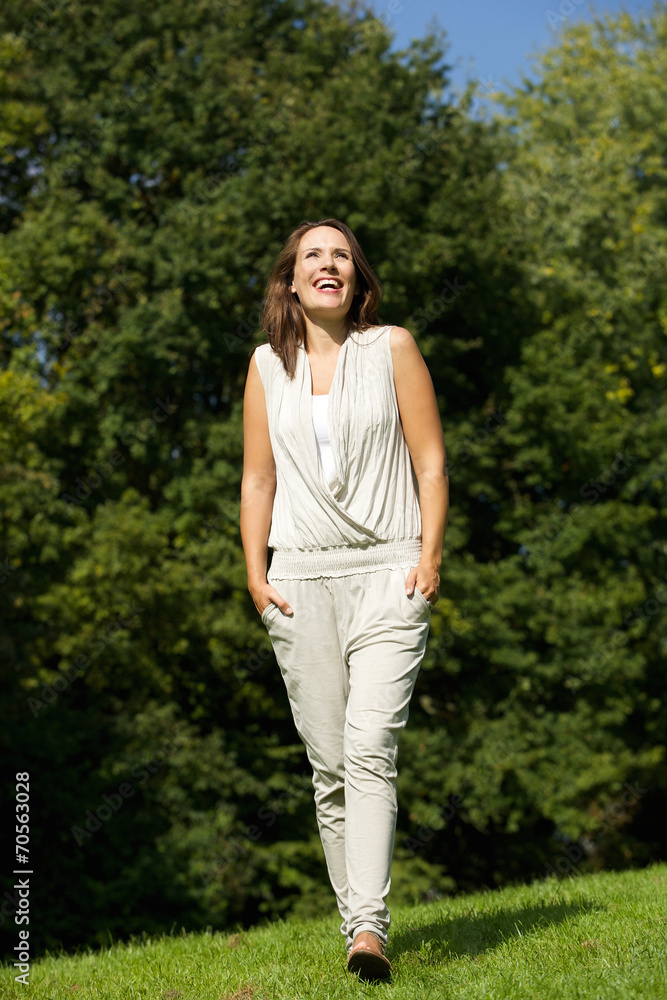 Smiling woman walking in the park Smiling woman walking in the park