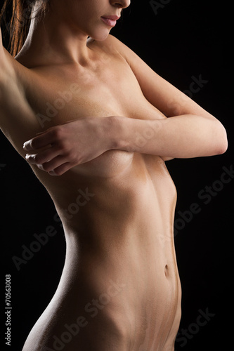closeup of nude young woman in front of black background.