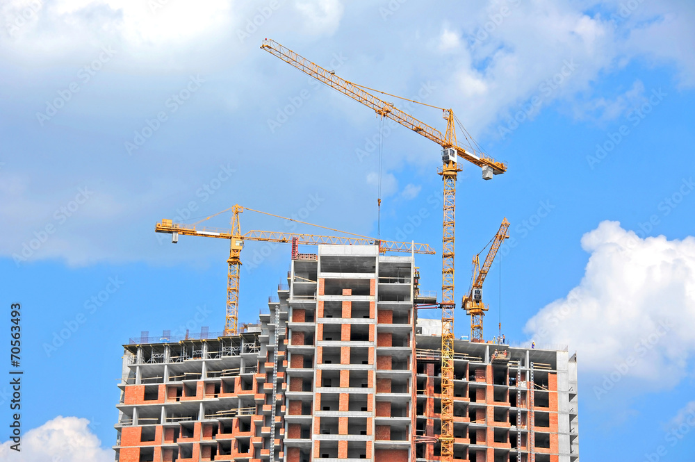 Crane and building construction site against blue sky Crane and building construction site against blue sky