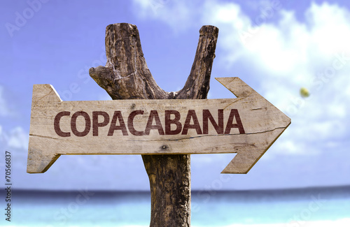 Copacabana wooden sign with a beach on background