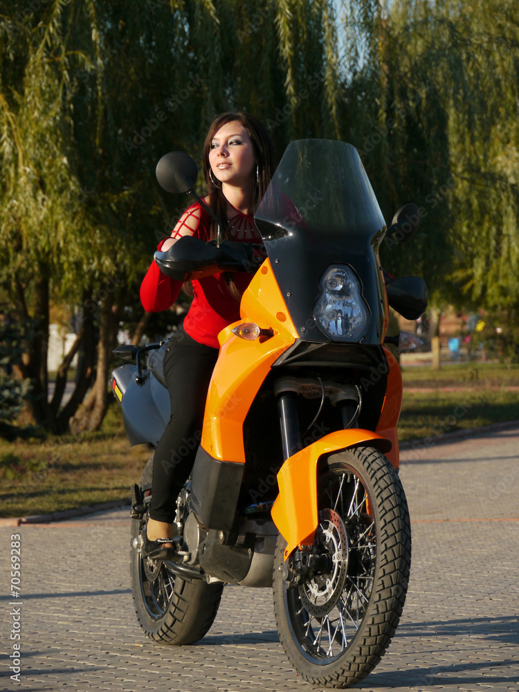 Beautiful young brunette on a motorcycle.