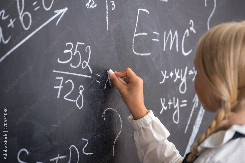 School girl writing on blackboard School girl writing on blackboard