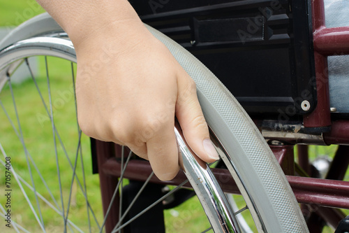 Hand an Rad von Rollstuhl