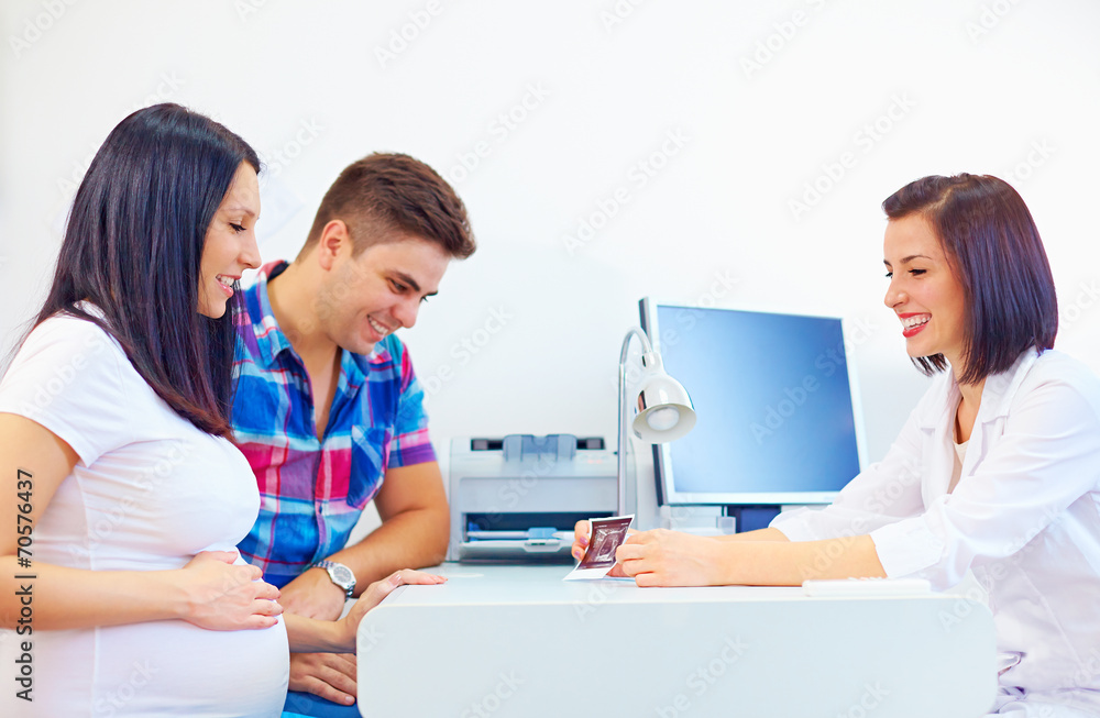 happy pregnant couple at the doctor office happy pregnant couple at the doctor office