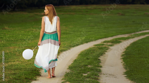 Woman walking with balloon in hand