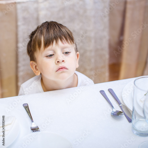 3 years old boy at an empty table