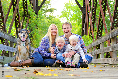 Portrait of Happy Family and Dog Outside in Fall