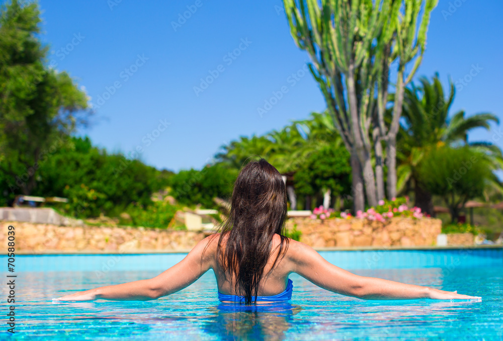 Beautiful young woman relaxing in swimming pool