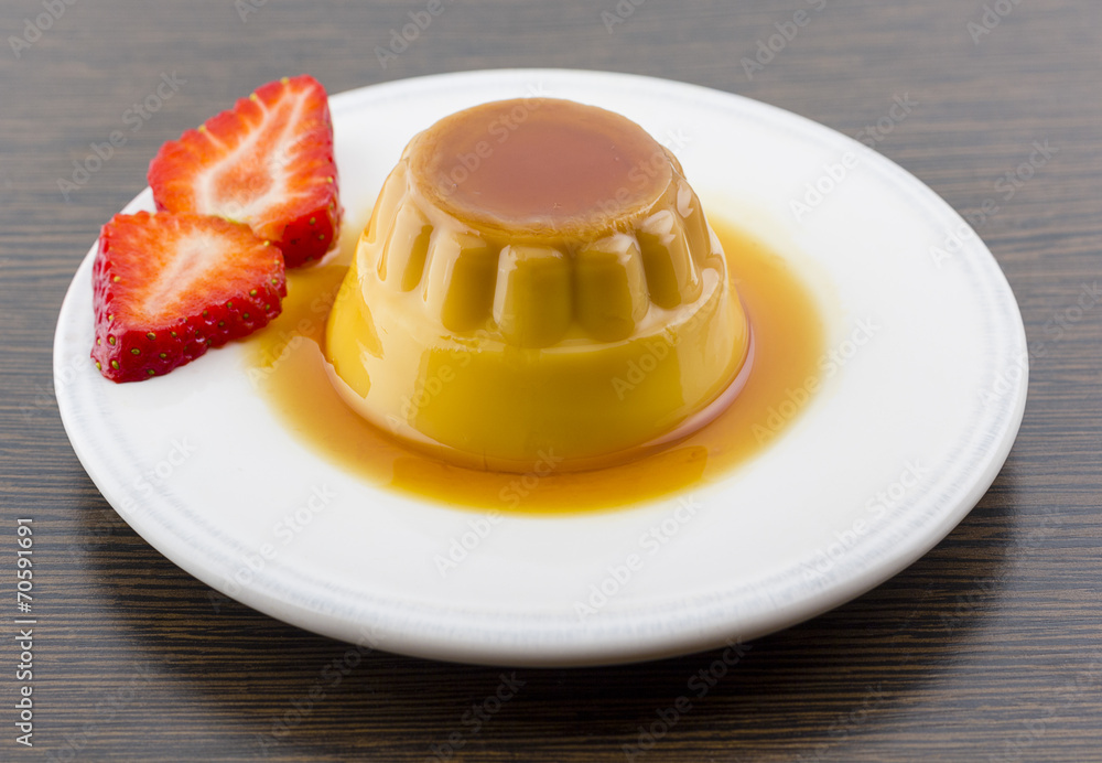 Creme caramel vanilla custard dessert or flan on white dish with Creme caramel vanilla custard dessert or flan on white dish with