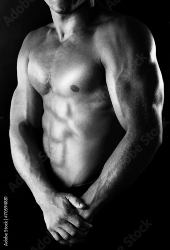Sexy muscular man on dark background in shades of grey