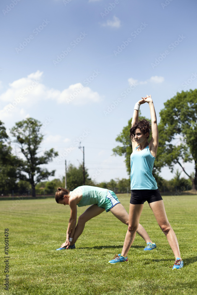 Two young girls stetching before a jogging Two young girls stetching before a jogging