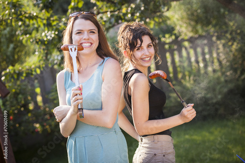 Two pretty girls making food on grill