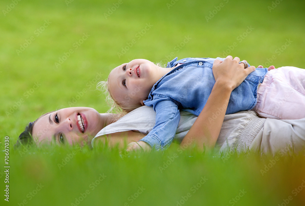 Smiling mother lying down on grass with cute baby Smiling mother lying down on grass with cute baby