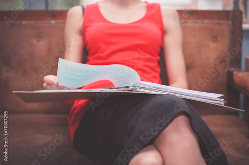 Woman sitting on sofa with documents photo