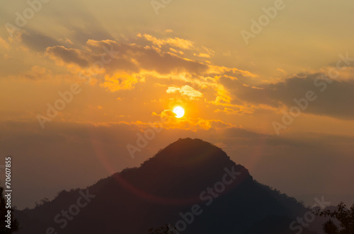 Sun with ring flare over mountain