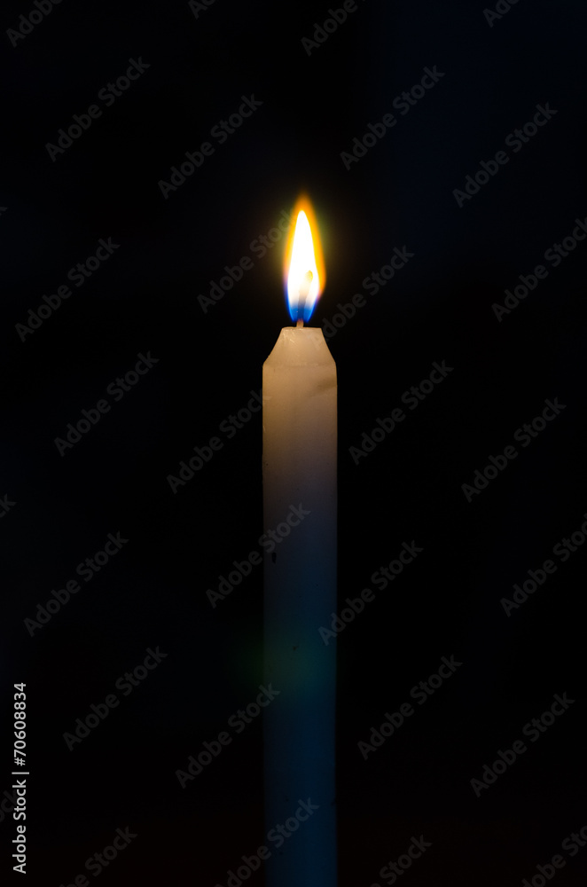 High burning candle on a black background High burning candle on a black background