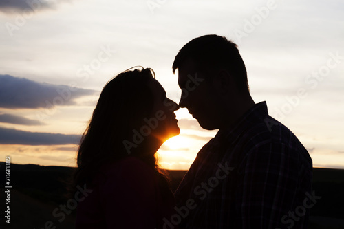 Silhouette of loving couple holding hands in heart shape over or