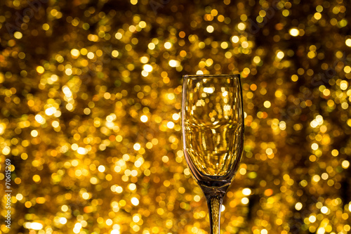 One champagne glass on christmas bokeh background