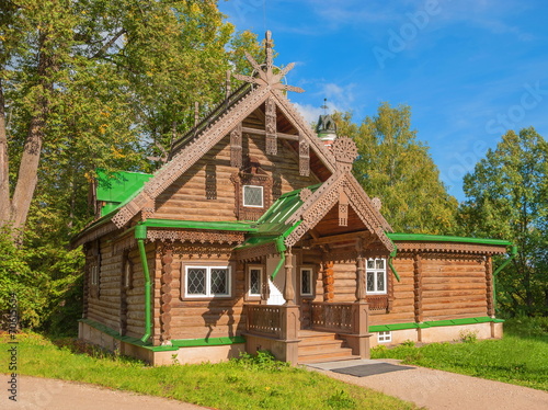 Old wooden house decorated with carvings in forest