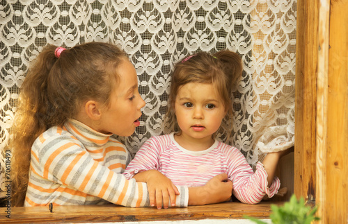 two happy girls talking on window at home